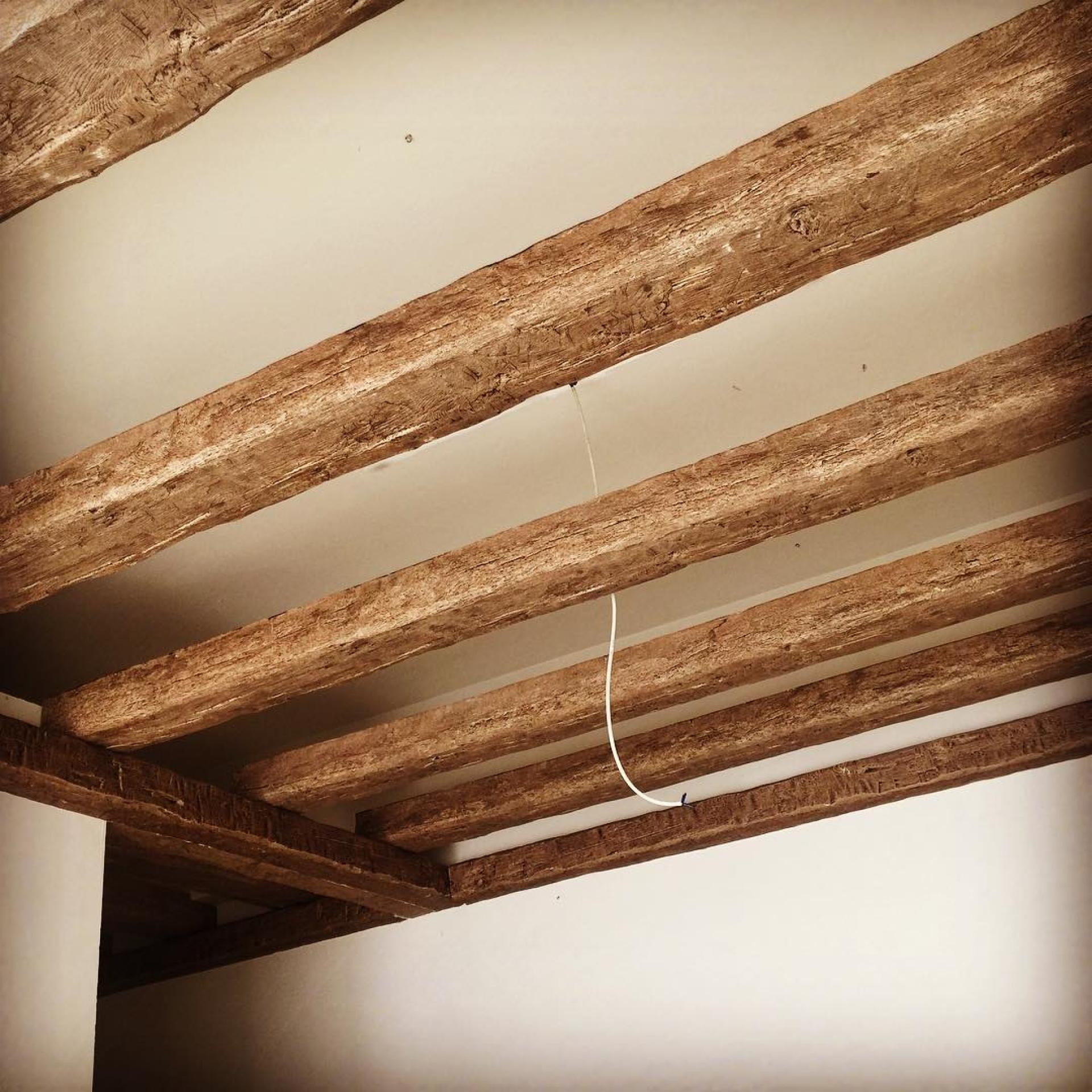 Tavan decorat cu grinzi din poliuretan cu aspect de lemn rustic P1981B și P1981C montate paralel pe fundal alb.