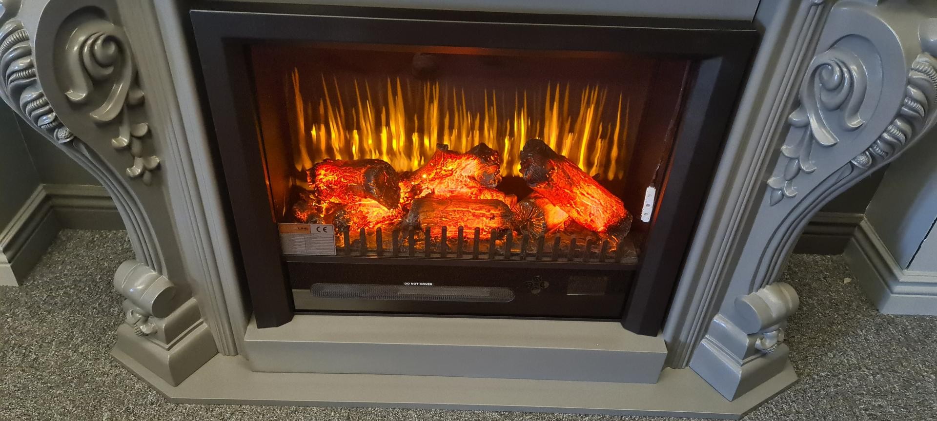 Ramă de șemineu din poliuretan P8403W vopsită în tonuri de gri mat, cu focar electric aprins în stil clasic.