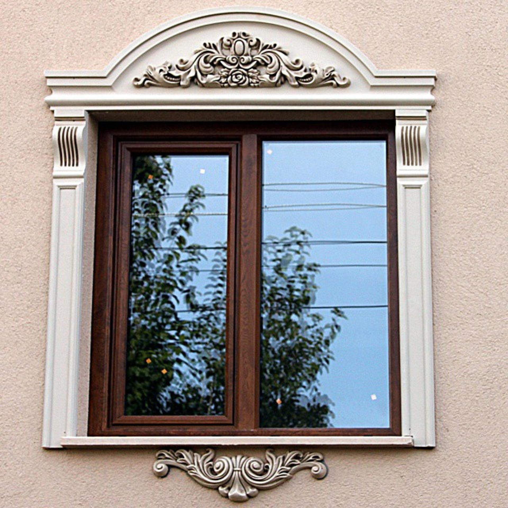 Ancadramente albe din poliuretan cu fronton decorativ clasic și pilatri pe o fațadă cu tencuială bej.