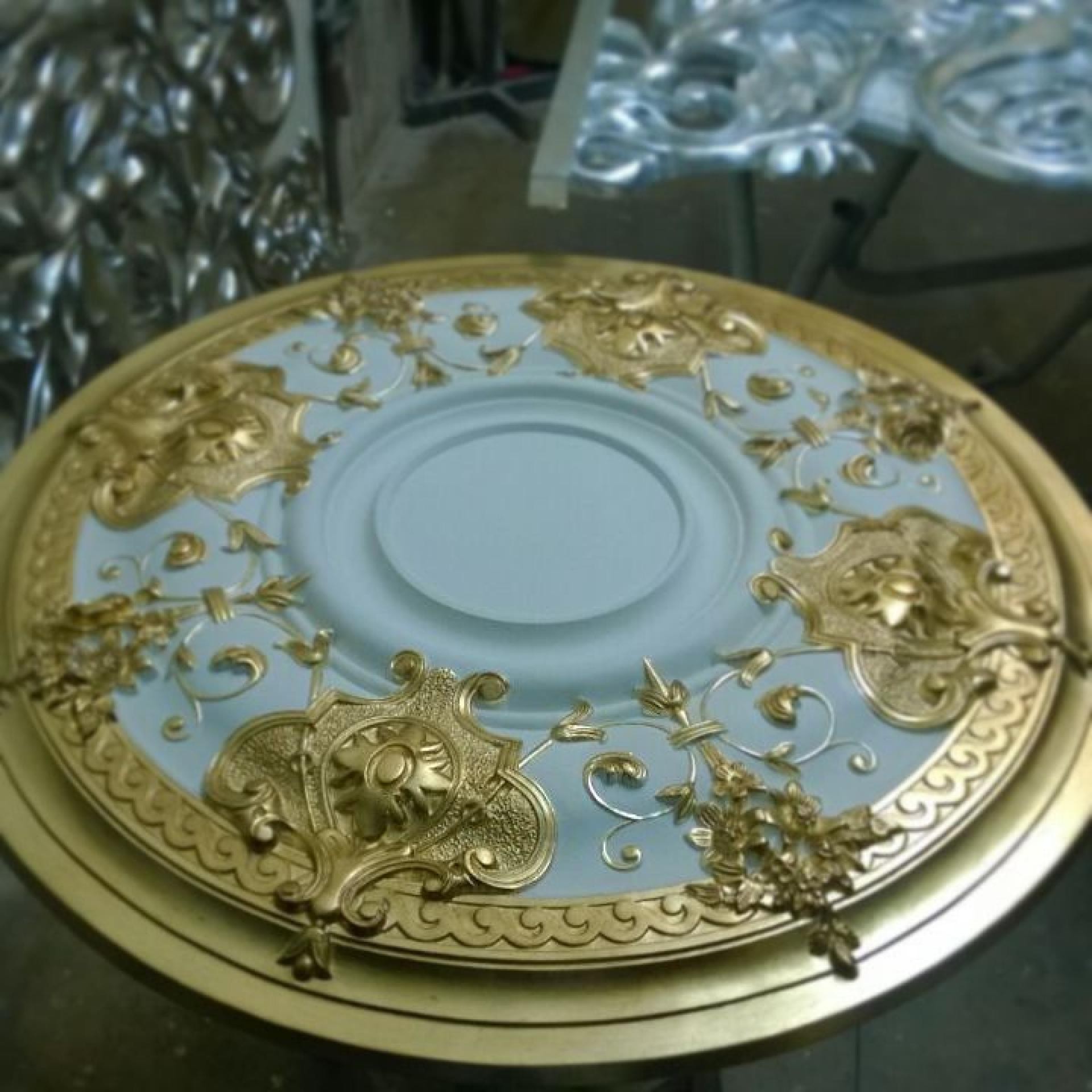 Rozetă rotundă din poliuretan P721 pictată în nuanțe de albastru pastel și reliefuri ornamentale aurite.