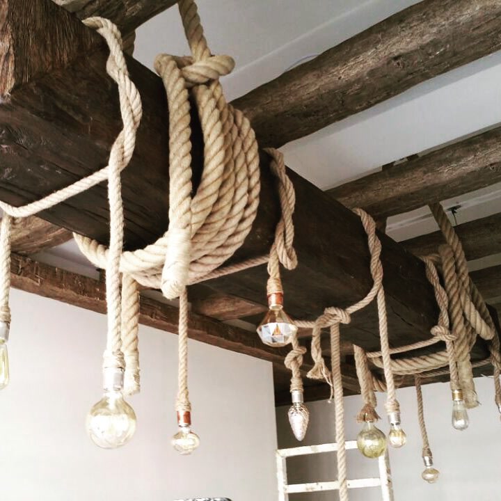 Grindă din poliuretan suspendată pe tavan alb cu frânghii groase și becuri decorative edison în stil rustic