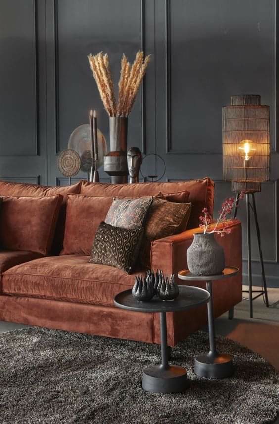 Perete gri antracit decorat cu profile din poliuretan P85403 lângă o sofa din catifea cărămizie într-un living modern.