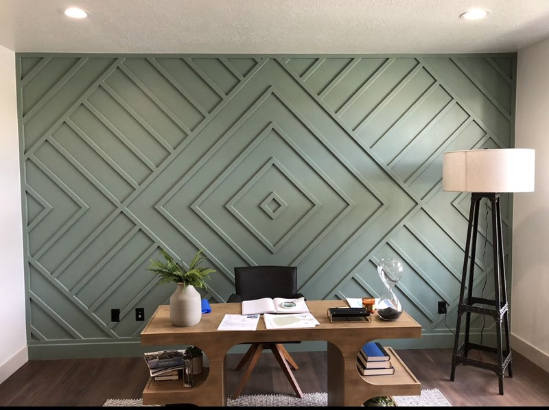 Perete accent verde salvie decorat cu profile din poliuretan în forme geometrice concentrate de romb în birou modern.