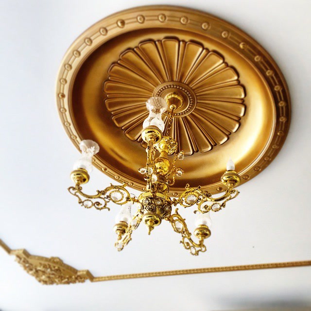 Rozetă și cupolă de tavan din poliuretan P9106 vopsită în auriu metalizat cu candelabru clasic într-o vilă.