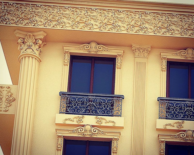 Fațadă clasică decorată cu coloane din poliuretan, ancadramente de fereastră și frize ornamentale decorative.