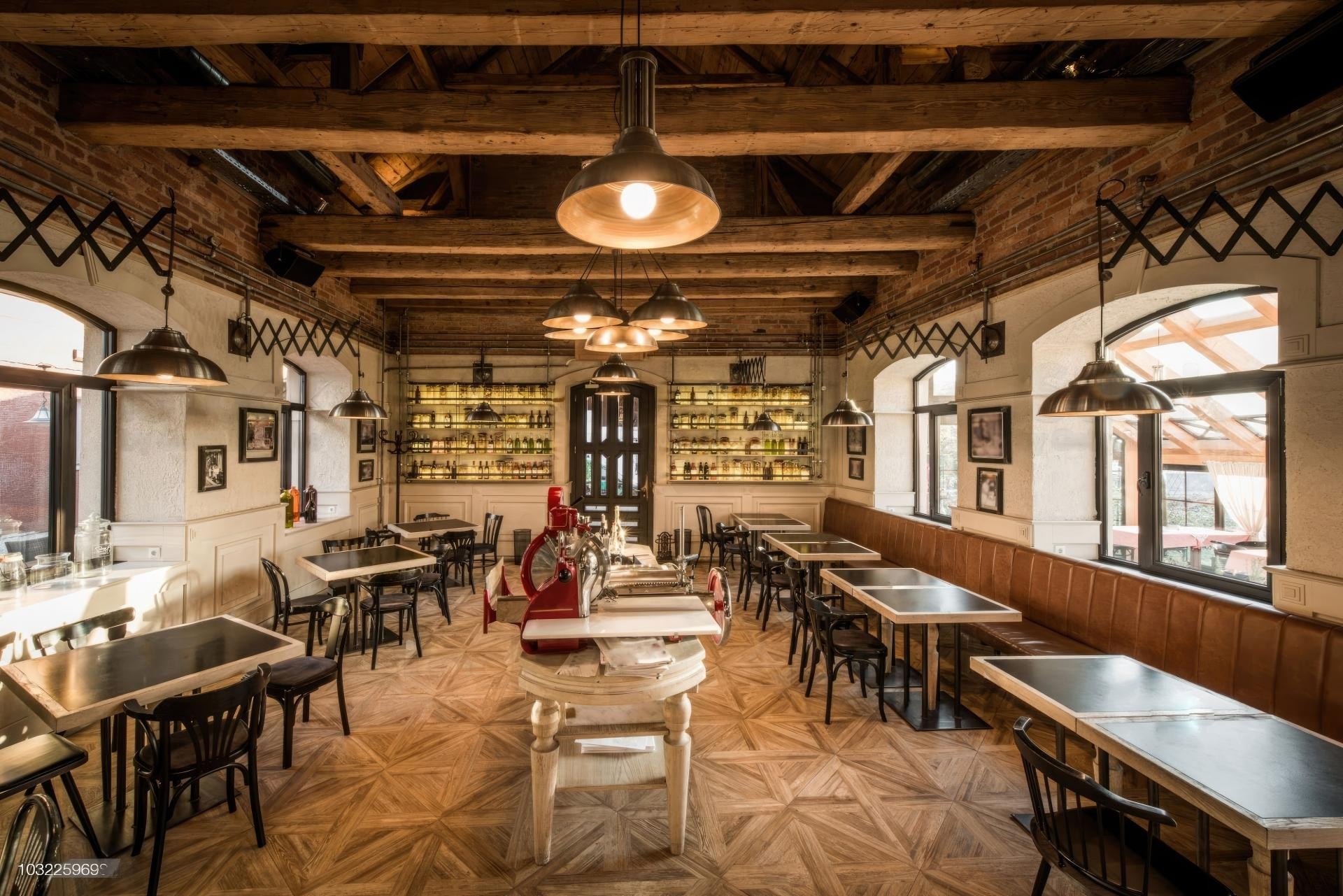 Tavan rustic de restaurant amenajat cu grinzi decorative din poliuretan și lămpi industriale suspendate.
