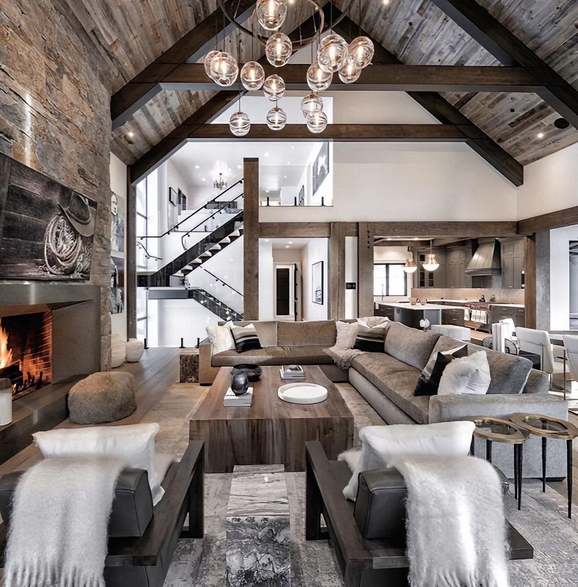 Living spațios cu plafon înalt decorat cu grinzi din poliuretan, șemineu din piatră și candelabru modern.