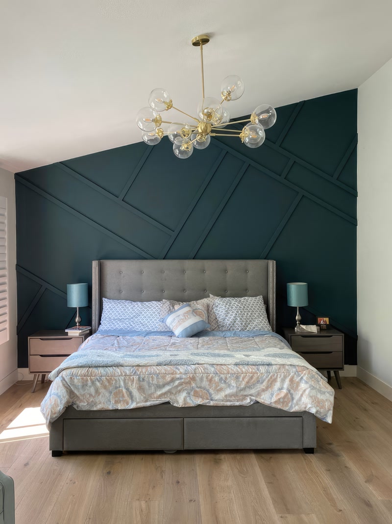 Perete accent verde smarald cu baghete decorative din poliuretan în dormitor modern cu lustră din alamă