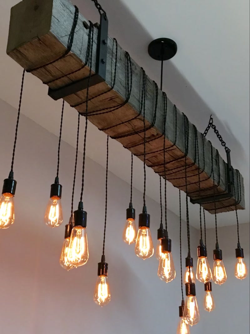 Grindă din poliuretan decorativă cu aspect de lemn vechi și cabluri cu becuri suspendate în stil rustic.