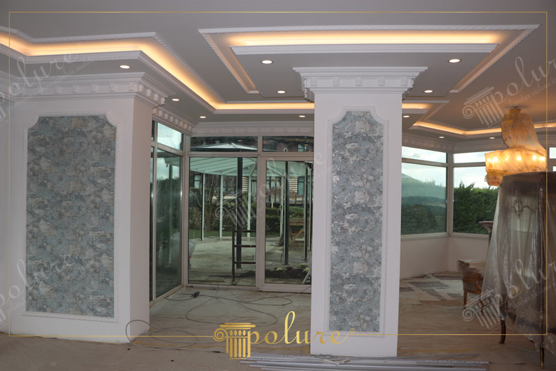 Amenajare interioară de salon cu scafă din poliuretan, iluminat LED integrat și coloane decorative încadrate.