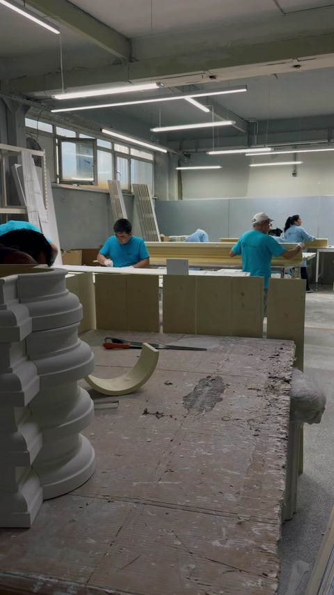 Hală de producție cu profile stivuite și mese lungi