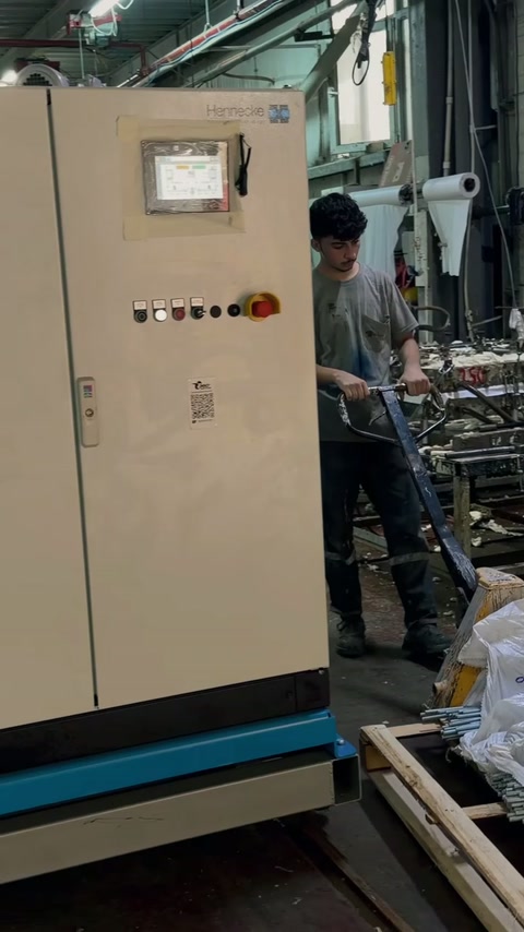 Un operator lucrează lângă tabloul de comandă al instalației industriale.