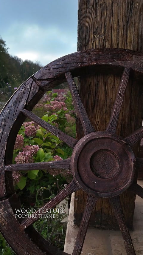 Roată decorativă și stâlp cu textură rustică de lemn, montate exterior.