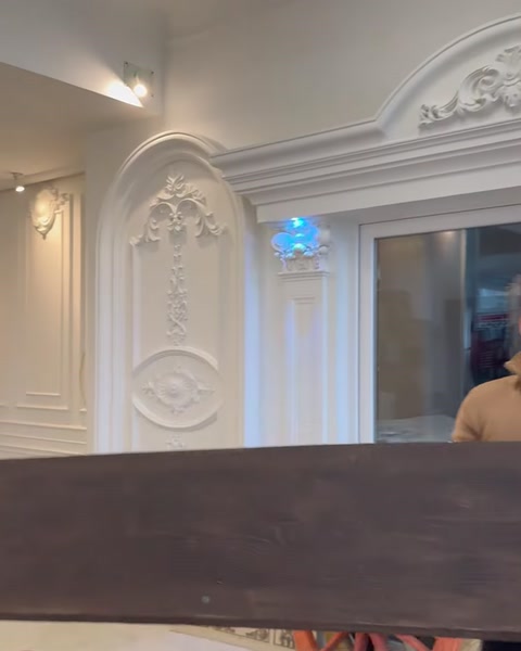 Grindă montată pe tavan ornamentat cu stucaturi albe