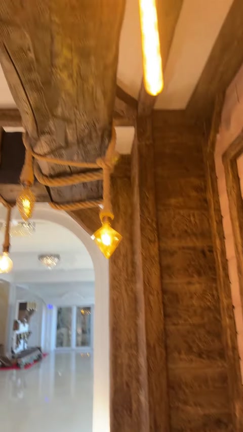 Grindă suspendată cu frânghie și becuri decorative calde.
