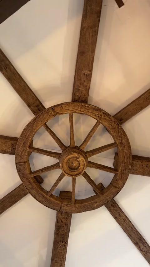 Compoziție radială din grinzi și ornament circular montată pe tavan.
