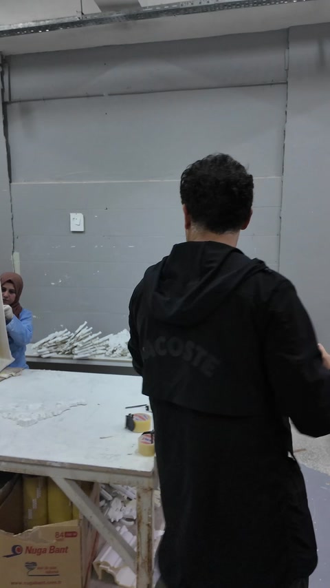 Angajat verifică materiale la masa de lucru din atelier