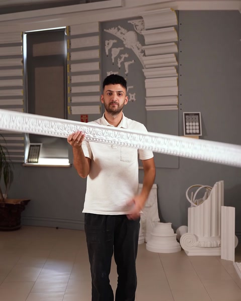 Bucată lungă de brâu rigid ținută orizontal pe umăr în showroom