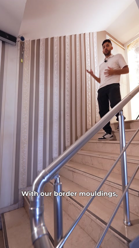 Bărbat coboară scările ținând un brâu lung, în showroom.