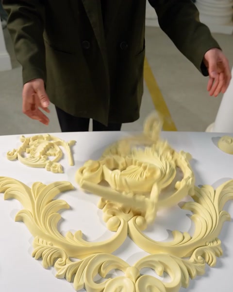 Mâini aranjează mai multe rozete decorative pentru tavan pe masă.