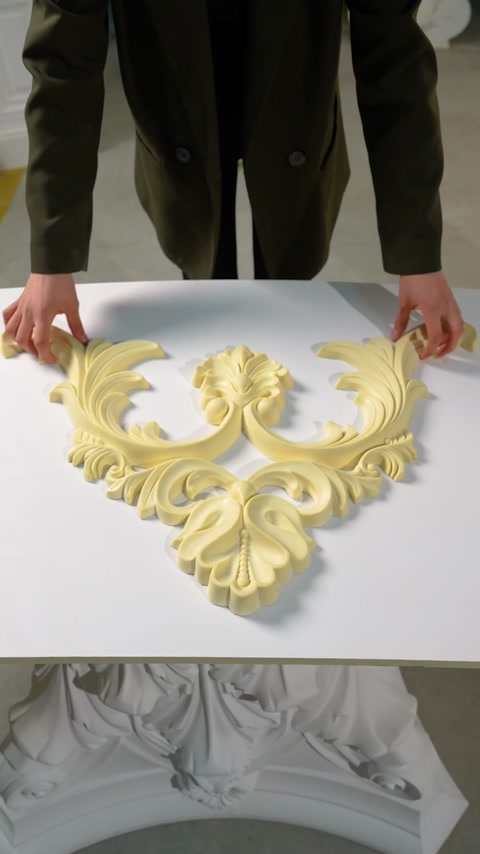 Componente ornamentale modulare sunt așezate împreună pe masa de lucru.