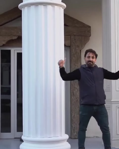 Muncitor cu brațele ridicate lângă un stâlp canelat finalizat