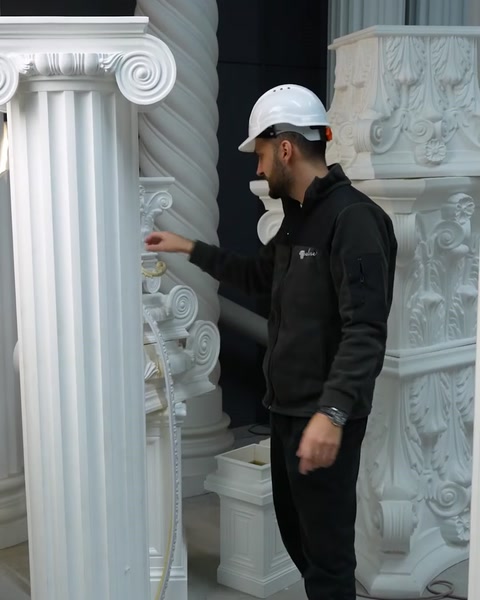 Muncitor arată o coloană înaltă din poliuretan în depozit.