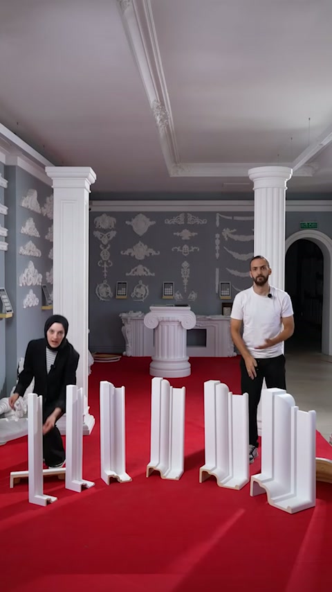 Prezentatorii stau în spatele gamei de ancadramente decorative expuse.