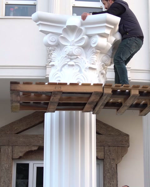 Montatorul ajustează capitelul ornamental pe structură