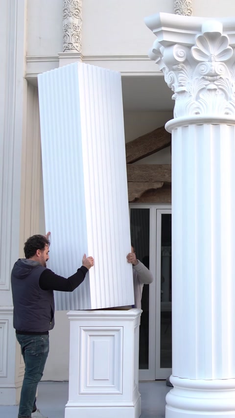 Coloană canelată monumentală prezentată alături de un capitel decorativ corintic