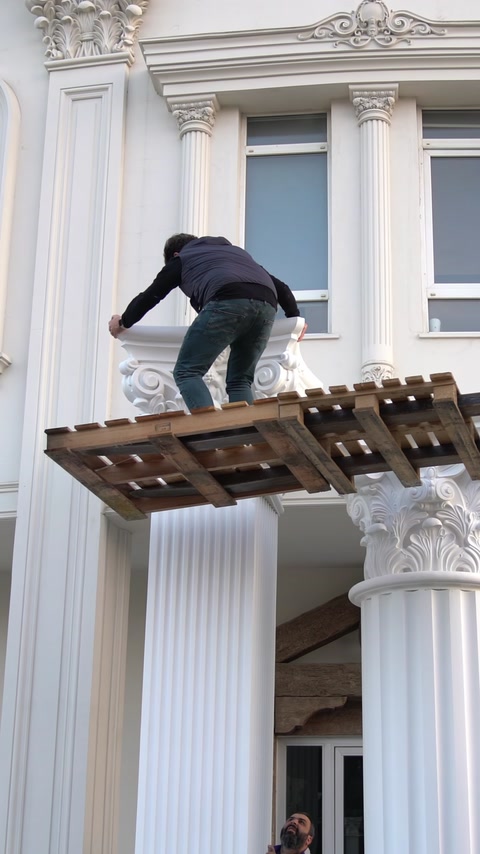 Lucrătorul ajustează elementele superioare ale ansamblului de coloane decorative