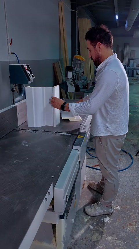 O bucată albă de mulură este poziționată pentru tăiere precisă.