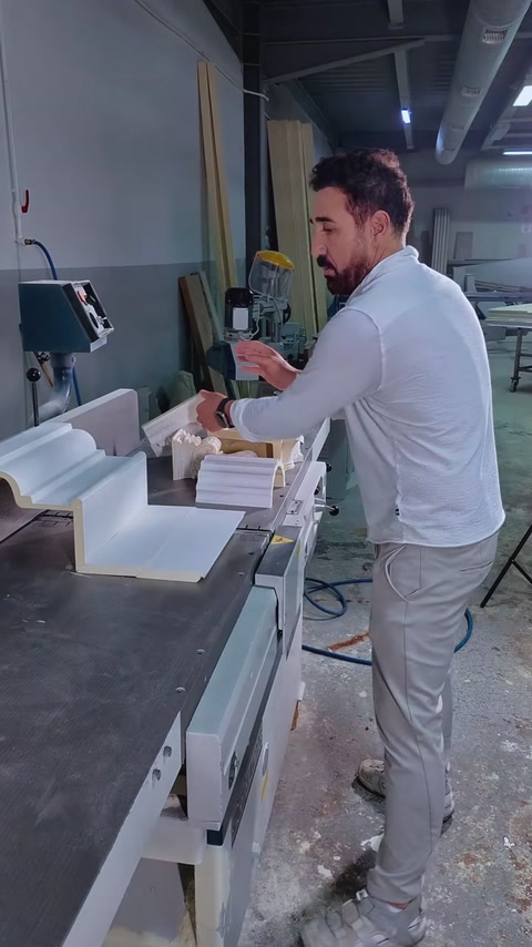 Piese albe de cornișă și console sunt pregătite pe banc.