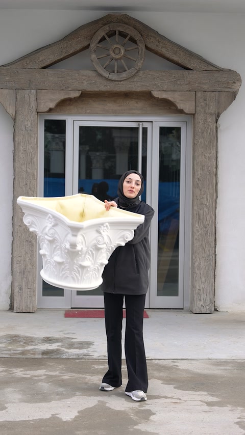 Capitel decorativ voluminos, prezentat manual în fața intrării ornamentate.