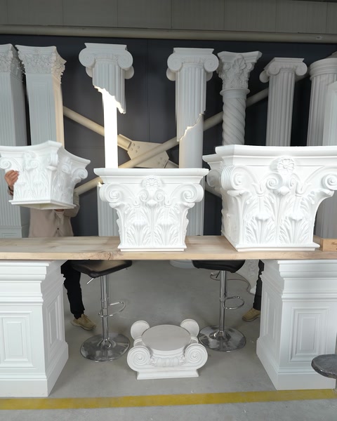 Detaliu al capitelurilor sculptate expuse pe suporturi din lemn.