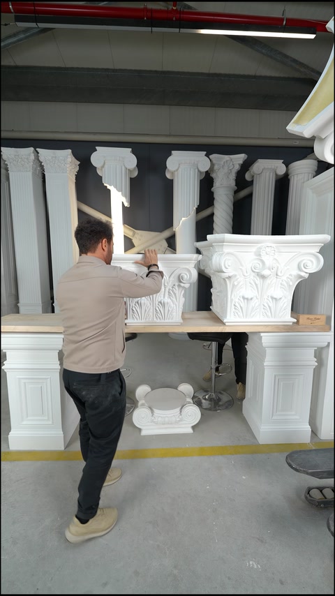 Lucrătorul pregătește capitelul decorativ așezat pe masa atelierului