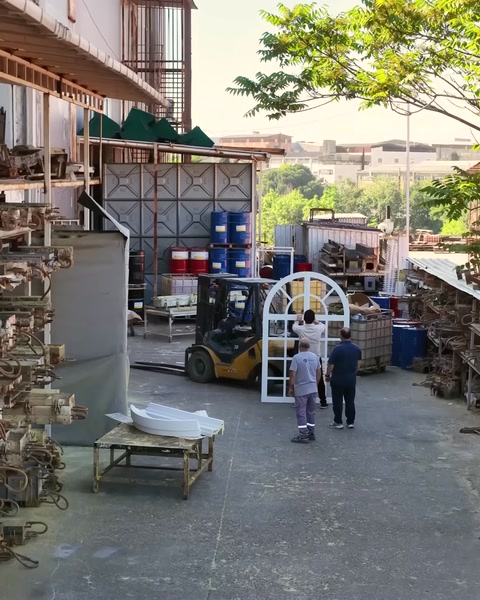 Curtea fabricii cu muncitori și materiale pentru producție