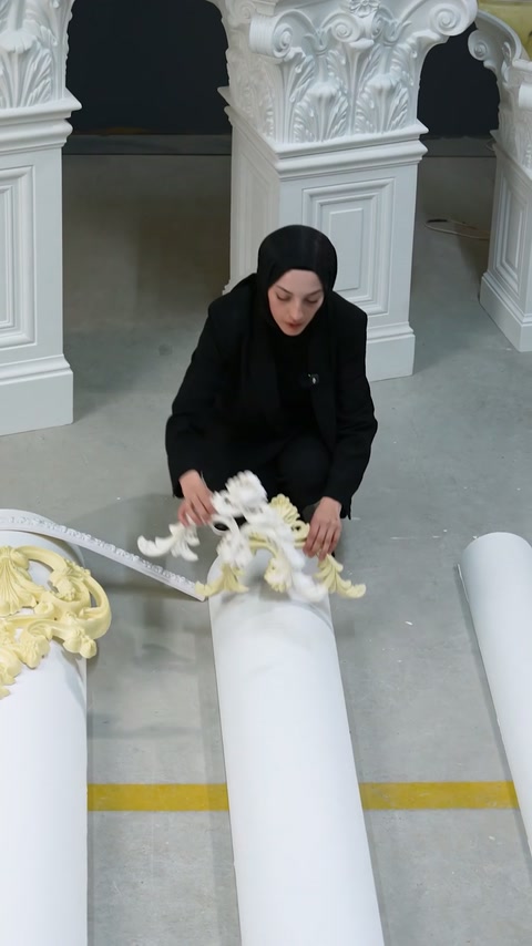 Ornamentul alb este modelat cu ambele mâini peste suportul cilindric.