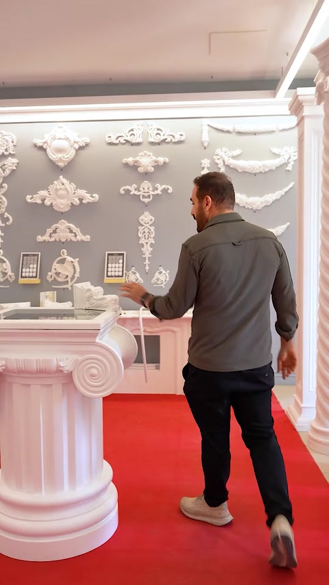 Spațiu expozițional cu șemineu decorativ, coloane și ornamente murale albe
