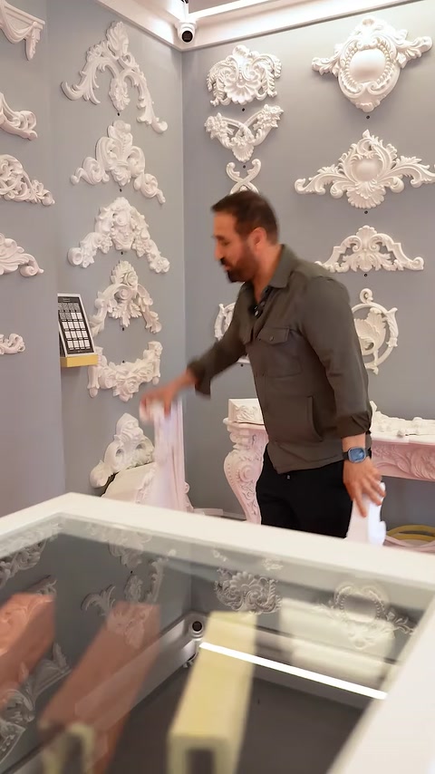 Prezentatorul alege o piesă dintre modelele expuse pe masă