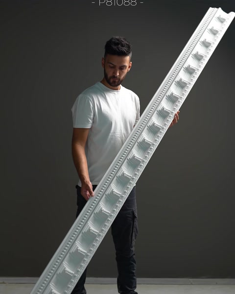 Cornișă lată cu model de blocuri dențate în relief.