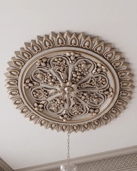 Rozetă ovală aurie montată pe tavan, deasupra unui candelabru