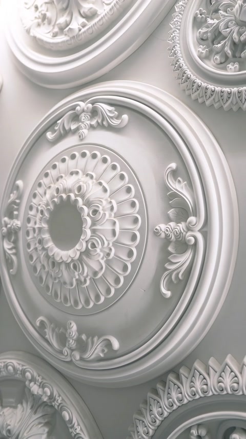Rozetă ovală albă, cu relief floral și margini concentrice ornamentate.
