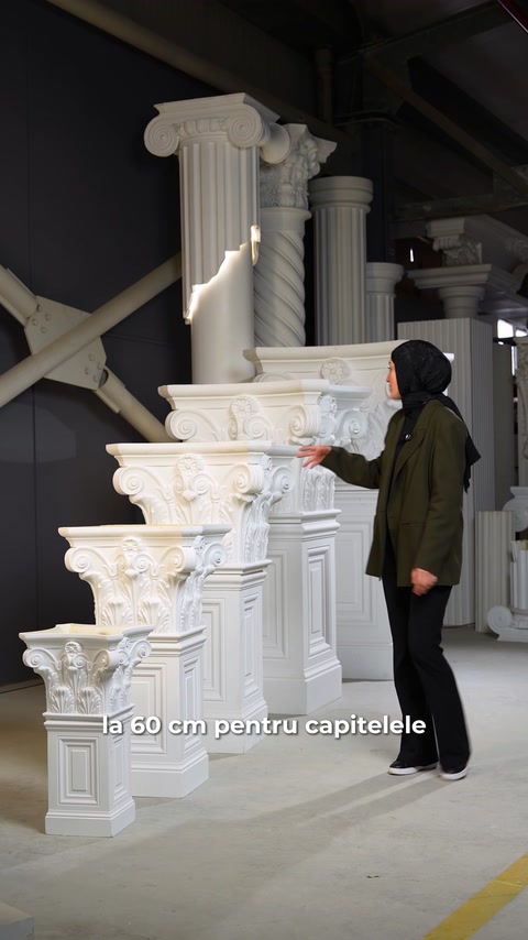 Colecție de capiteluri ornamentale expuse alături de coloane decorative.