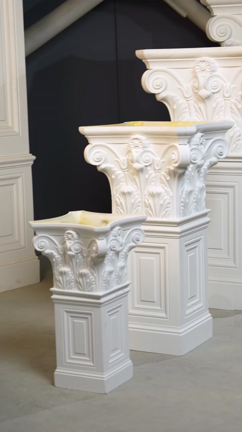 Capiteluri clasice de mărimi diferite, aliniate pe piedestale ornamentale.