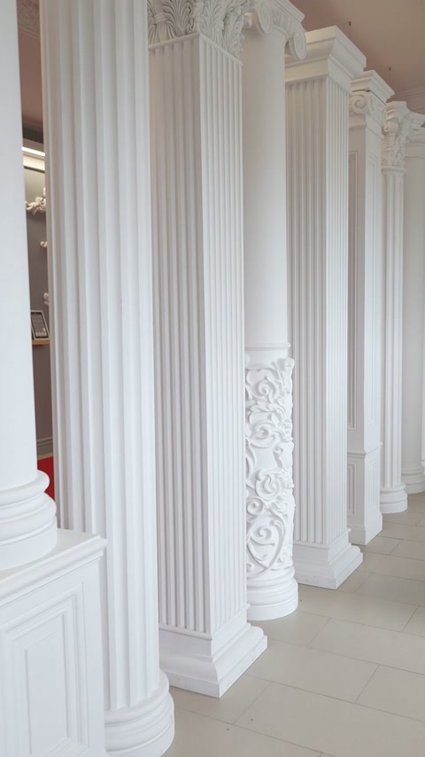 Șir de coloane canelate cu capiteluri și baze decorative albe