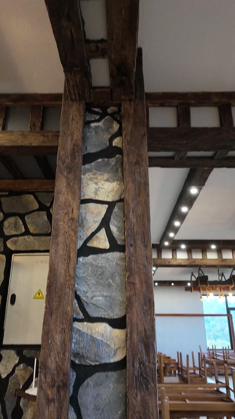 Grindă verticală decorativă montată lângă placarea murală din piatră