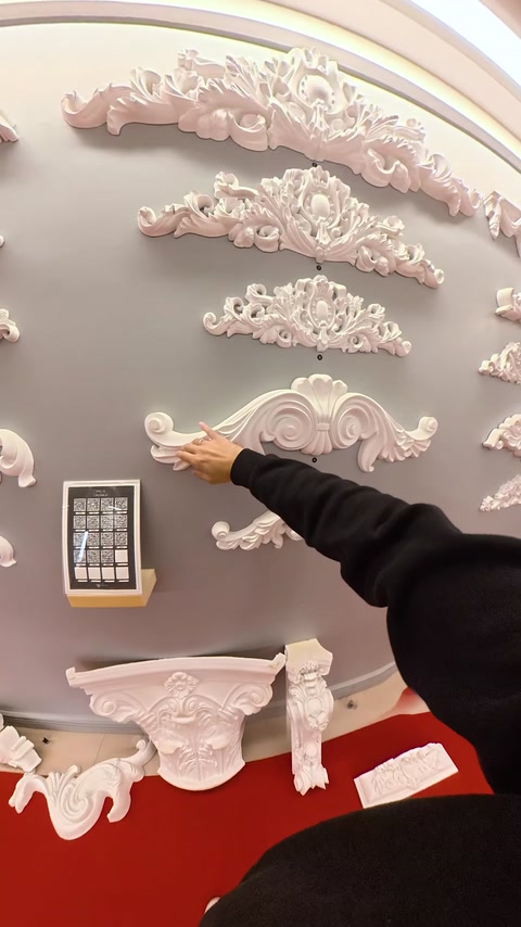 Element decorativ alb cu volute este prezentat pe panoul showroomului.