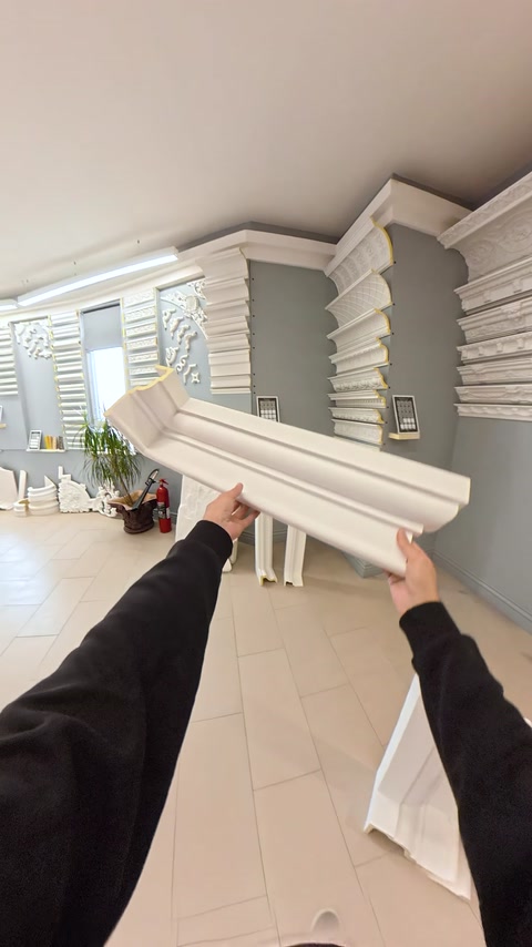 Cornișă albă profilată este prezentată împreună cu un element vertical.