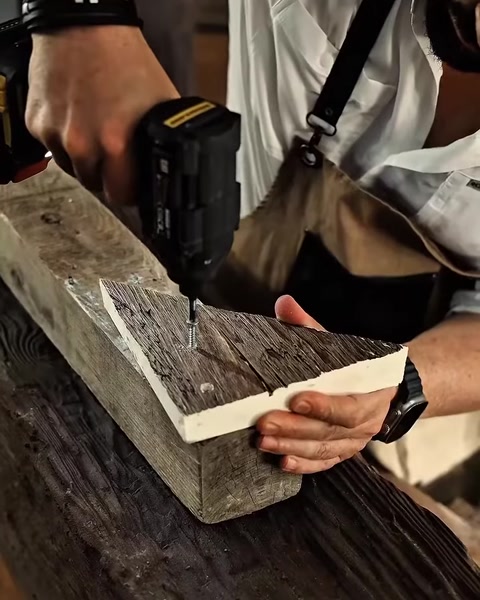 Detaliu cu bormașina la îmbinarea în colț a două grinzi decorative.